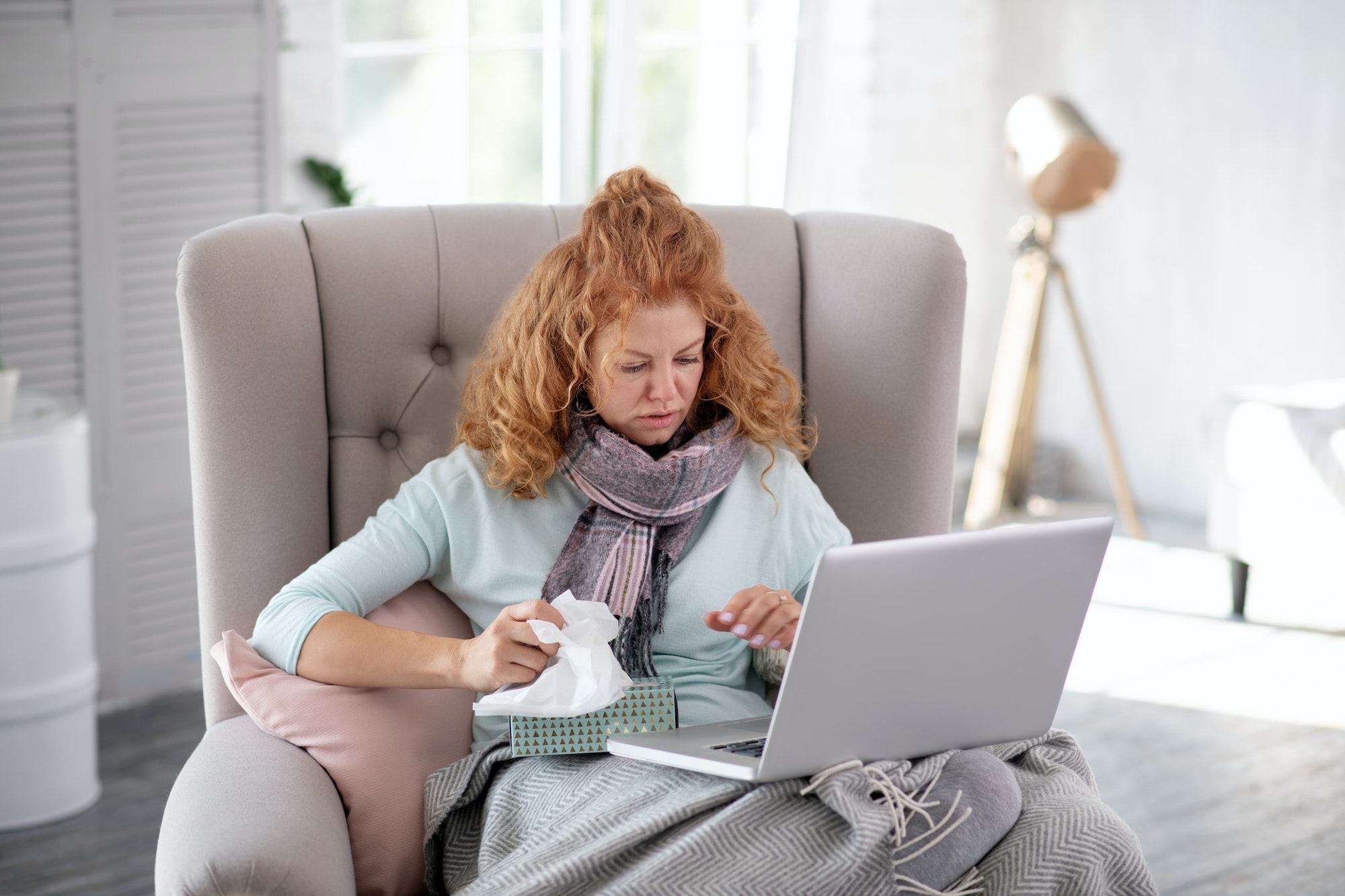 Red-haired young woman making doctor appointment online