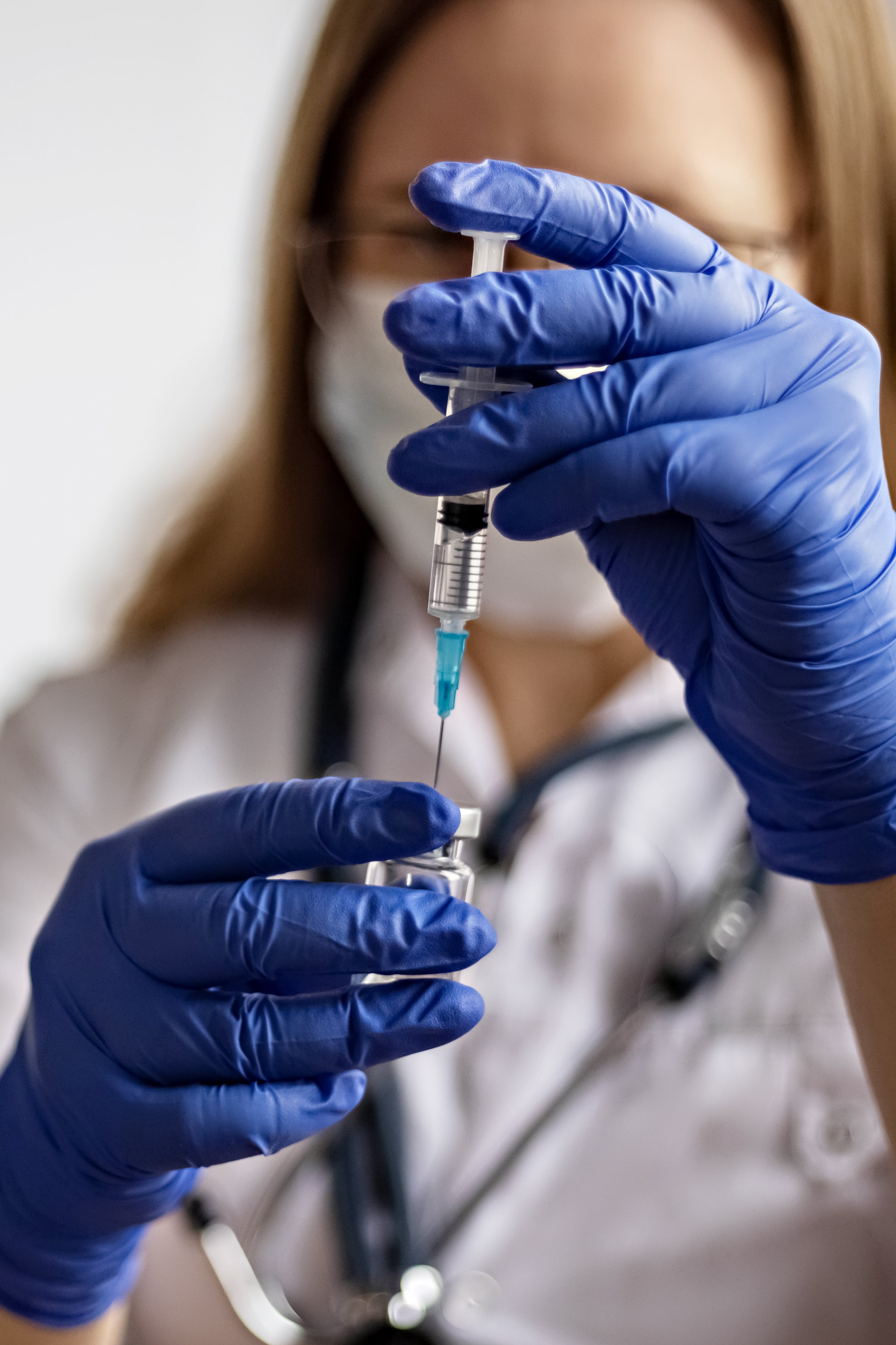 A doctor draws the coronavirus vaccine into a syringe.The concept of vaccination, immunization.